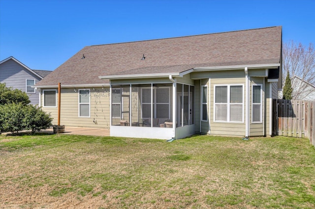 back of property featuring a shingled roof, a sunroom, a yard, and fence