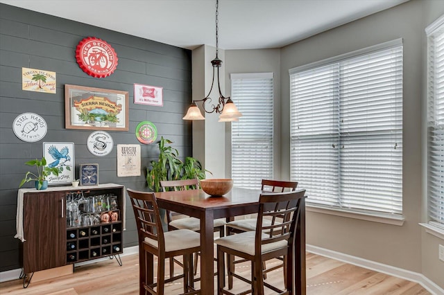 dining room featuring light wood-style floors, baseboards, and a wealth of natural light