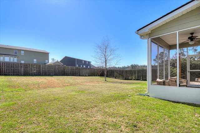 view of yard featuring fence, a sunroom, and ceiling fan