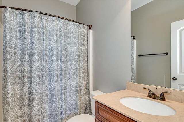 bathroom with vanity, curtained shower, and toilet