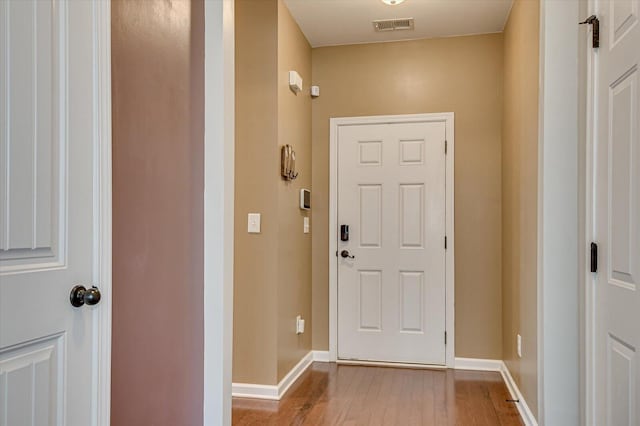 doorway to outside with visible vents, baseboards, and wood finished floors