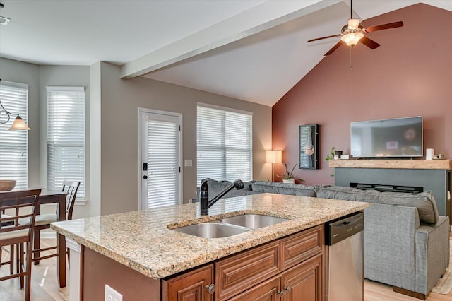 kitchen featuring a sink, light stone counters, stainless steel dishwasher, open floor plan, and ceiling fan