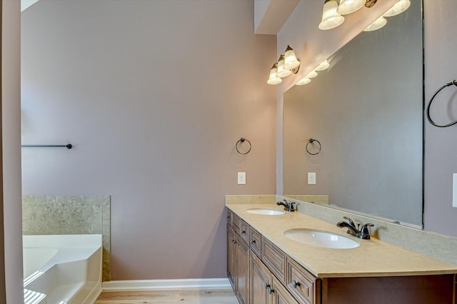 bathroom with double vanity, a bath, baseboards, and a sink