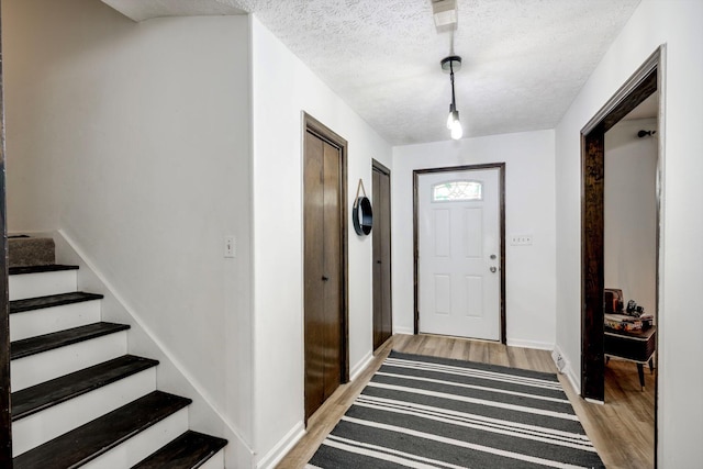 707 Oriole St, Aiken, SC 29803 - entrance foyer with light wood-type flooring, a textured ceiling, stairs, and baseboards
