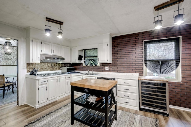 707 Oriole St, Aiken, SC 29803 - kitchen featuring beverage cooler, under cabinet range hood, light wood-type flooring, a sink, and brick wall