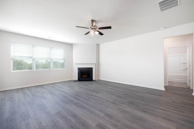 unfurnished living room featuring ceiling fan and dark wood-type flooring