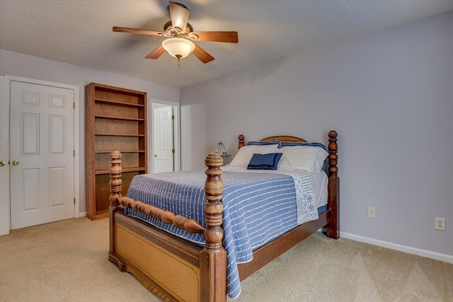 bedroom featuring light colored carpet, baseboards, and a ceiling fan