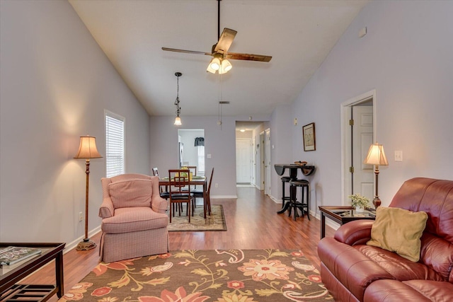 living room with lofted ceiling, baseboards, wood finished floors, and ceiling fan