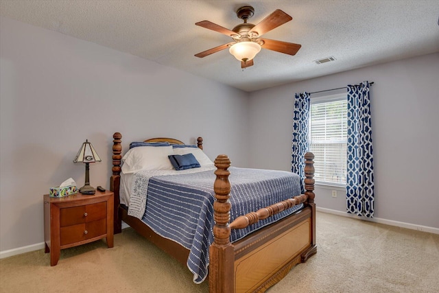 bedroom with visible vents, baseboards, light carpet, and a textured ceiling