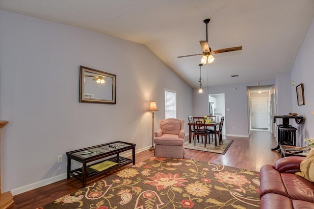 living area with wood finished floors, ceiling fan, baseboards, and lofted ceiling