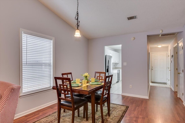 dining space featuring visible vents, baseboards, and wood finished floors