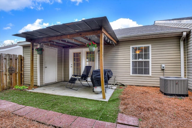 back of property with roof with shingles, fence, a patio, and central air condition unit