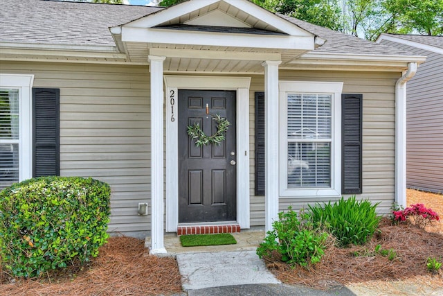 entrance to property featuring a shingled roof
