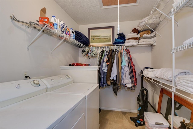 laundry area featuring light carpet, a textured ceiling, attic access, independent washer and dryer, and laundry area