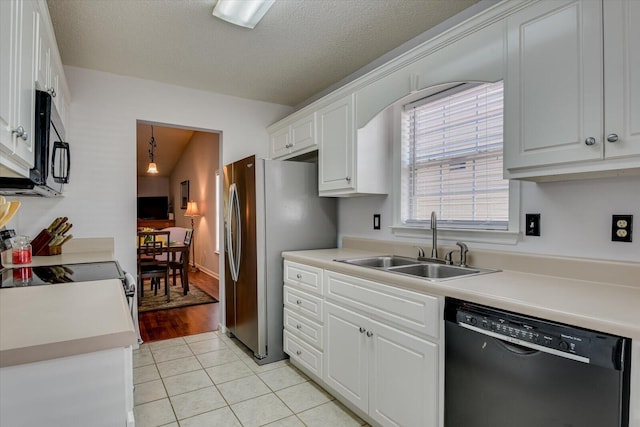 kitchen featuring light tile patterned floors, white cabinets, black dishwasher, a sink, and light countertops
