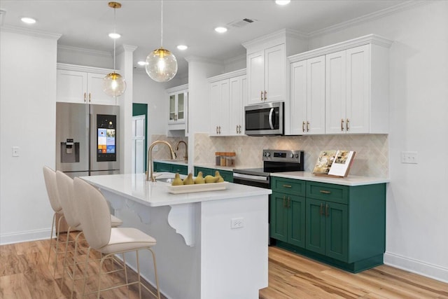 kitchen with green cabinets, stainless steel appliances, decorative backsplash, and crown molding