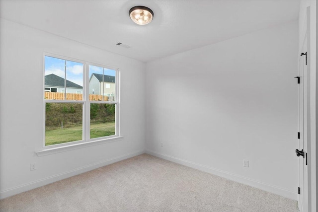 spare room with carpet floors, baseboards, and a wealth of natural light