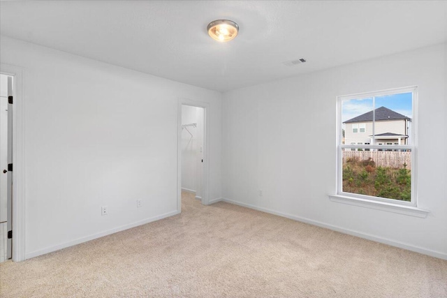 spare room featuring visible vents, baseboards, and carpet flooring