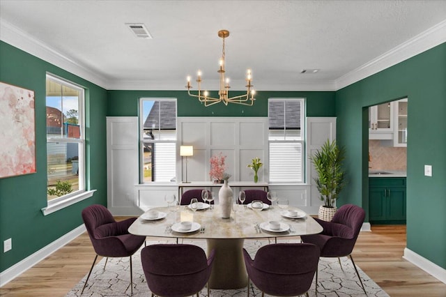 dining room featuring plenty of natural light, an inviting chandelier, and light wood-style floors