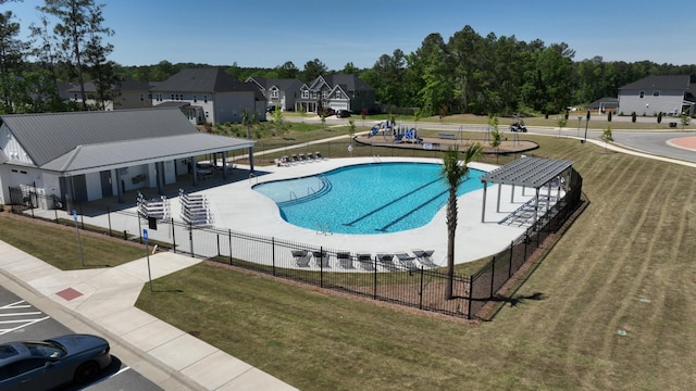 community pool featuring a residential view, fence, a patio, and a yard