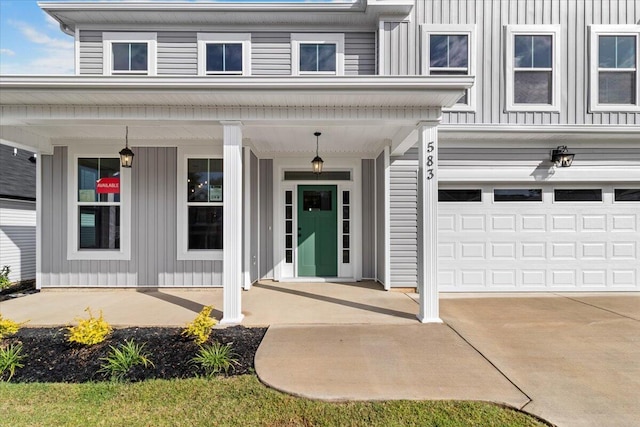 property entrance featuring covered porch, driveway, board and batten siding, and an attached garage