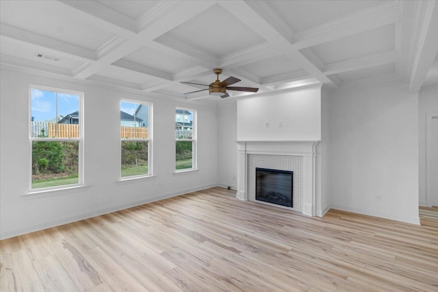 unfurnished living room featuring beam ceiling, light wood finished floors, a tiled fireplace, coffered ceiling, and baseboards