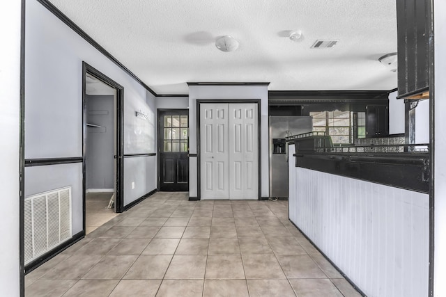 1736 Goshen Rd, Augusta, GA 30906 - kitchen with stainless steel fridge, a textured ceiling, ornamental molding, and light tile patterned flooring