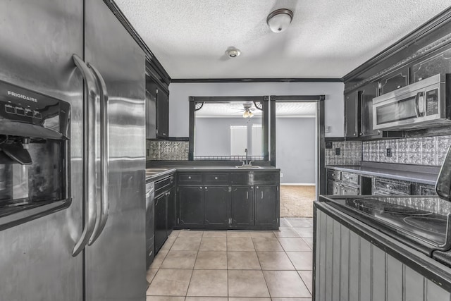 1736 Goshen Rd, Augusta, GA 30906 - kitchen with stainless steel appliances, dark cabinetry, dark countertops, crown molding, and light tile patterned flooring