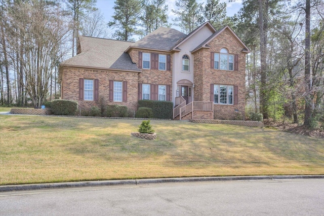 view of front facade featuring brick siding, roof with shingles, and a front lawn