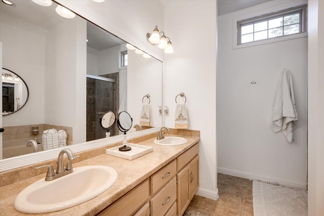 bathroom featuring a sink, baseboards, a stall shower, and double vanity