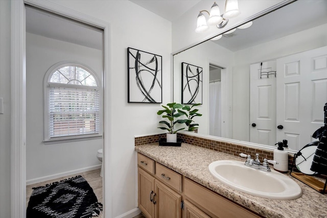 full bathroom featuring backsplash, toilet, vanity, and baseboards