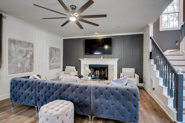 living room with wood finished floors, crown molding, and a ceiling fan