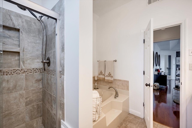 full bath featuring a garden tub, a stall shower, and tile patterned flooring