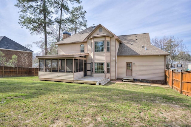 back of property featuring a lawn, a chimney, a fenced backyard, and a sunroom