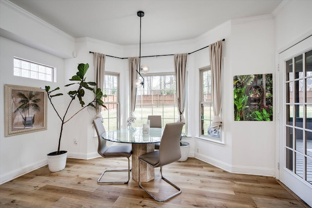 dining area with ornamental molding, baseboards, and wood finished floors