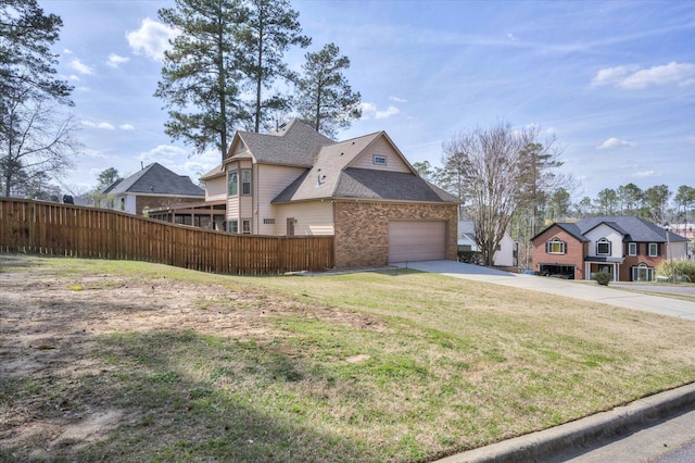 view of side of property featuring a garage, a lawn, concrete driveway, and fence