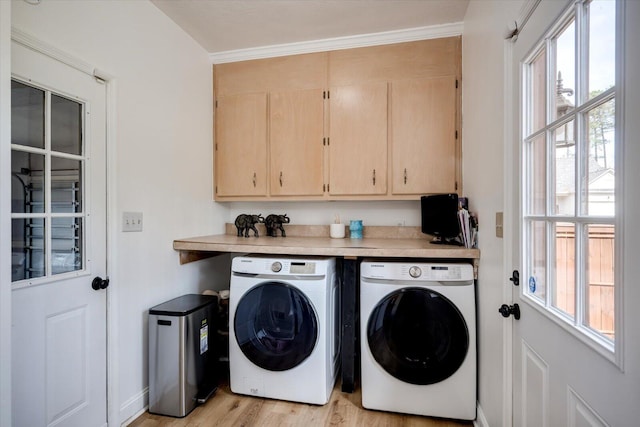 laundry area featuring cabinet space, light wood finished floors, and washing machine and clothes dryer