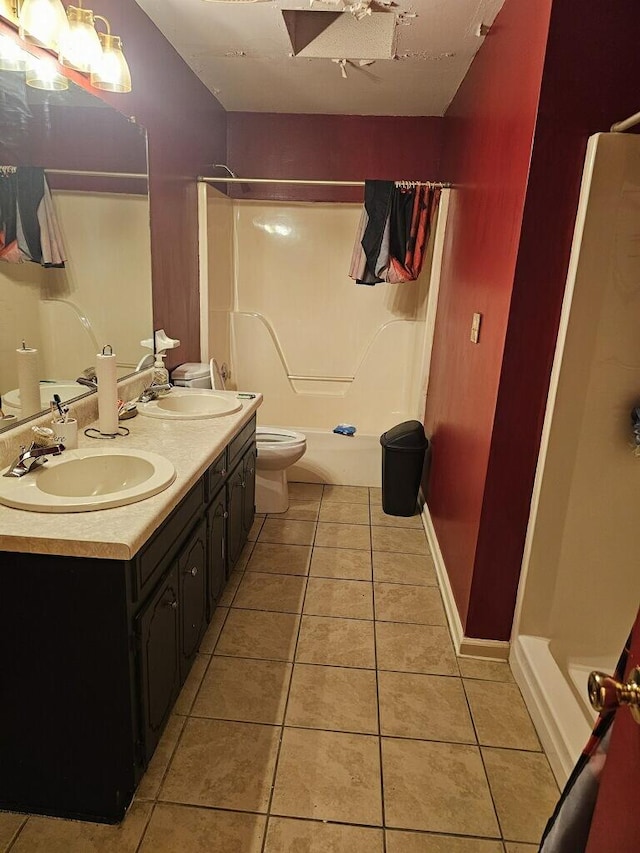 full bathroom with tile patterned floors, double vanity, a sink, and toilet