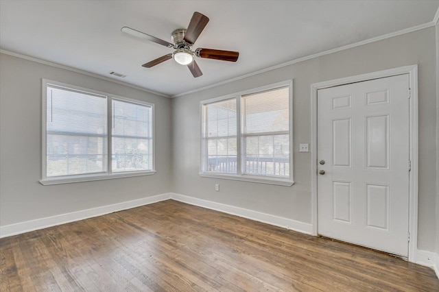 foyer entrance featuring hardwood / wood-style flooring, plenty of natural light, ornamental molding, and ceiling fan