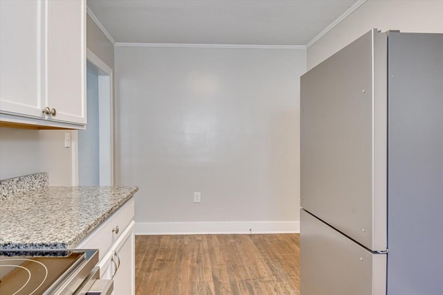 kitchen featuring white cabinetry, stainless steel fridge, crown molding, and light wood-type flooring