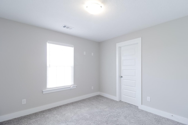 empty room featuring visible vents, baseboards, and carpet flooring