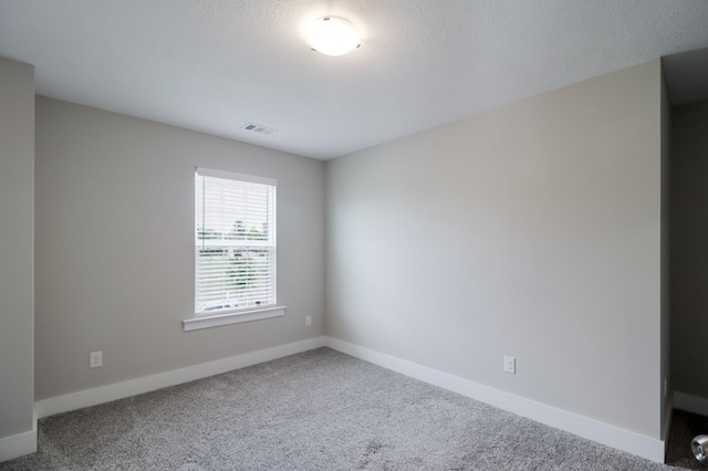 carpeted empty room with visible vents and baseboards
