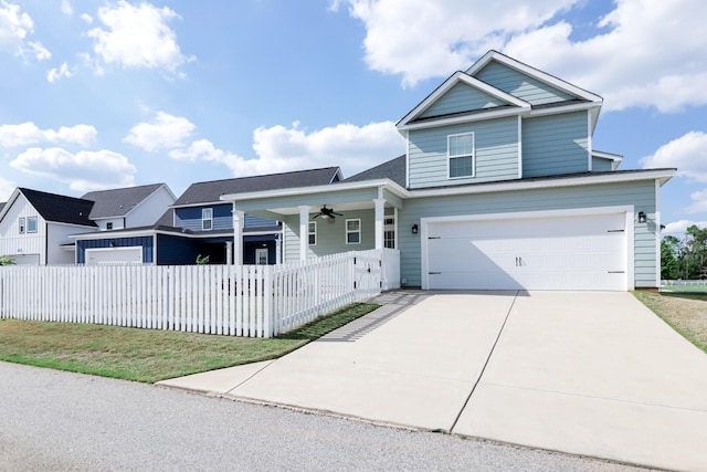 traditional home with a ceiling fan, driveway, a garage, and fence