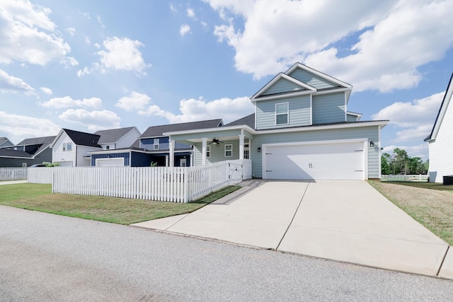 view of front of home with concrete driveway, a garage, a front yard, and fence