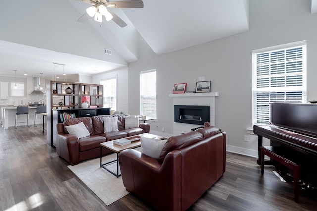 living room featuring dark wood-type flooring, baseboards, a ceiling fan, and visible vents