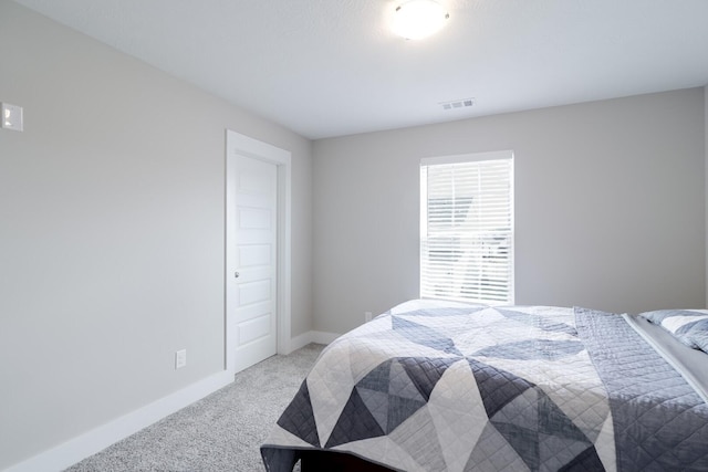 bedroom with light carpet, visible vents, and baseboards