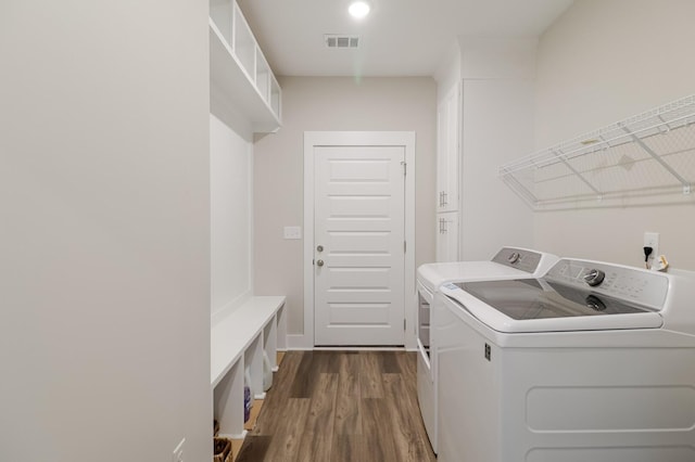 laundry area featuring visible vents, washing machine and clothes dryer, laundry area, and dark wood finished floors