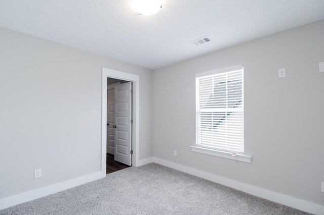 unfurnished bedroom with baseboards, carpet, and visible vents