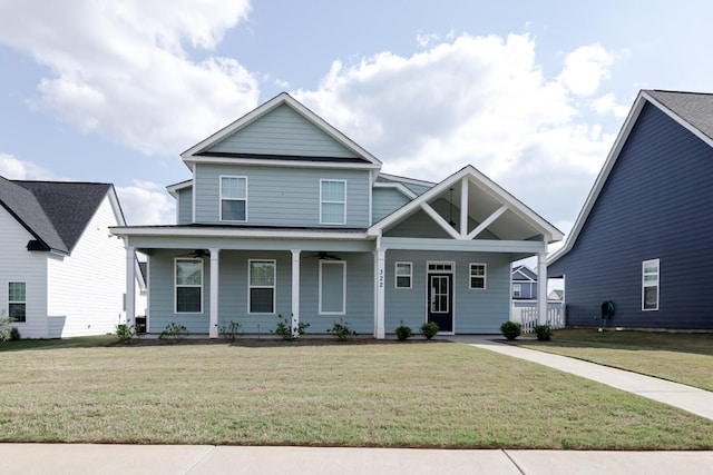 craftsman-style home featuring a front yard, ceiling fan, and covered porch