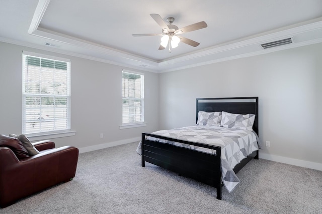 bedroom with crown molding, visible vents, a tray ceiling, and carpet floors